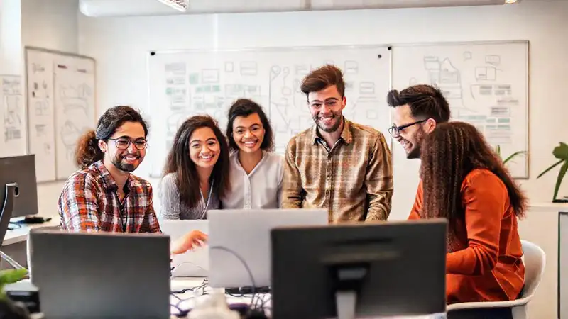 Programadores diversos colaboran en un ambiente optimista